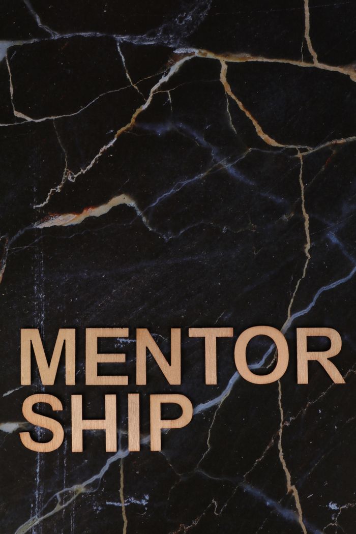 about-us Wooden letters spelling 'MENTORSHIP' on a dark marble background, inspiring guidance and support.