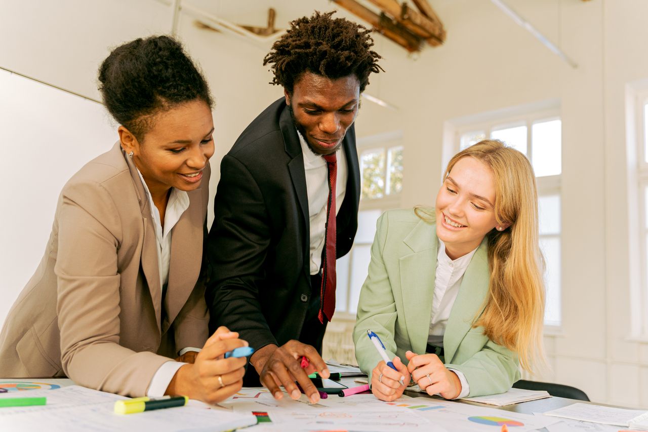 Diverse colleagues engaged in teamwork at an office, collaborating on a project with enthusiasm.